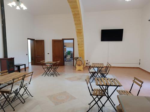 a room with tables and chairs and a flat screen tv at Bed & Breakfast Ilary in Marsala