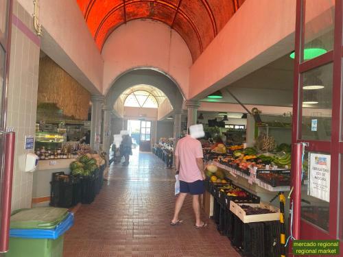 a man is standing in a grocery store aisle at Villa Kethellen in Porto Covo