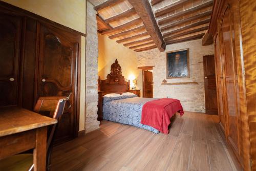 a bedroom with a bed with a red blanket at Degli Alessandri house in Sassoferrato