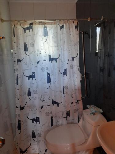 La salle de bains est pourvue d'un rideau de douche avec des chats. dans l'établissement LOS CLAVELES, à Dichato