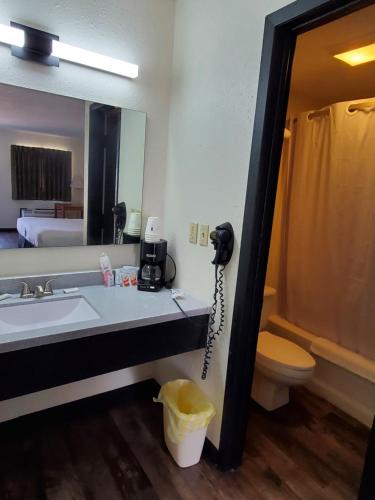 a bathroom with a sink and a phone on the wall at Cactus Inn and Suites in Mountain Grove