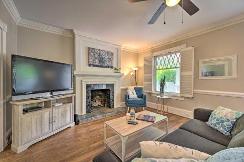 a living room with a large television and a fireplace at Bright Greensboro Escape about 1 Mi to Downtown in Greensboro