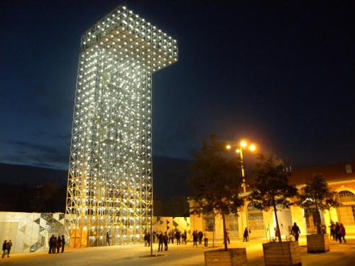 a large building with lights on it at night at Ibis Saint Étienne - La Terrasse in Saint-Étienne
