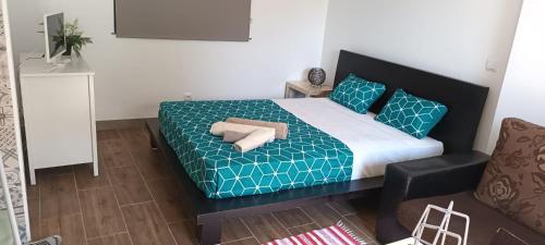 ein Schlafzimmer mit einem Bett mit blau-weißer Bettwäsche und einem Stuhl in der Unterkunft Victoria 1942 in Funchal