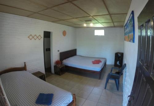 a bedroom with a bed and a chair in it at Bananoz Surfhouse in Transito