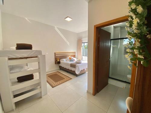 a bedroom with a bunk bed and a bathroom at Pousada Villa Vantino in Penha