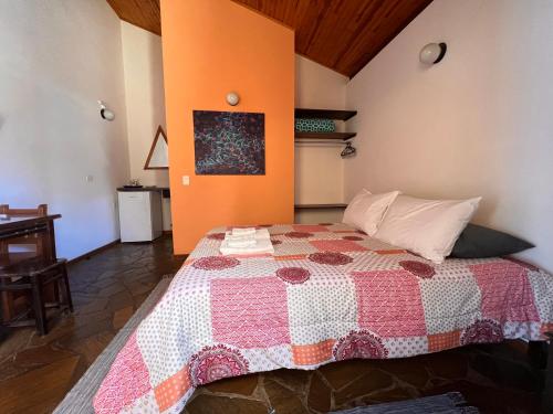 a bedroom with a bed with a quilt on it at Hospedaria Vila Khepri in Gonçalves