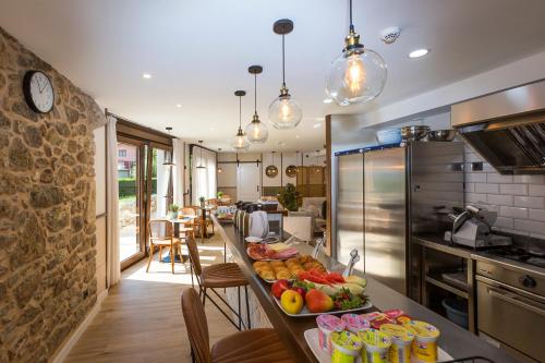 una cocina con una mesa larga llena de frutas y verduras en Pensión *** O Relax do Río, en Muxía