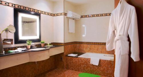 a bathroom with a tub and a sink and a mirror at GRANADA l'Amitié in Bamako