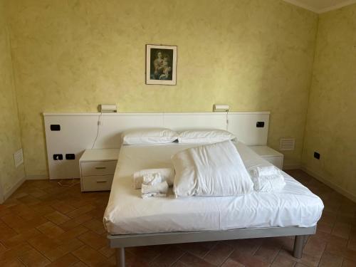 a bedroom with a bed with white sheets and pillows at Piamarta Apartments in Toscolano Maderno