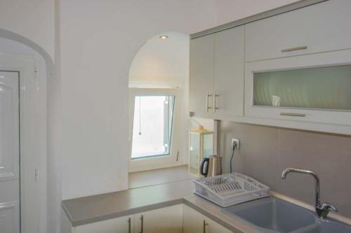 a kitchen with a sink and a window at Kafenes Home in Mesaria