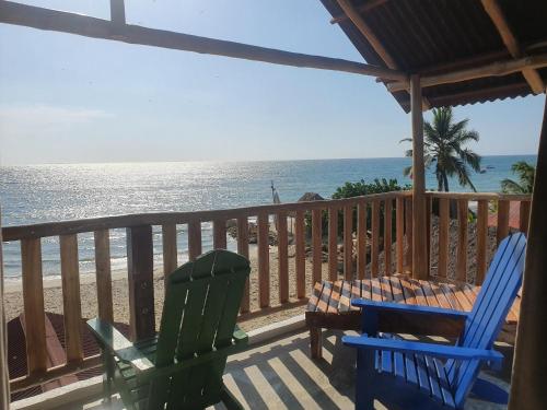 two chairs and a table on a balcony overlooking the beach at Mamallena Beachside Rincon del Mar in Rincón