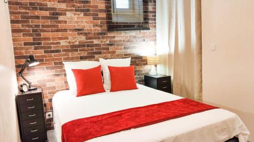 a bedroom with a brick wall and a bed with red pillows at VILLA REIALA Plan-de-Cuques in Marseille