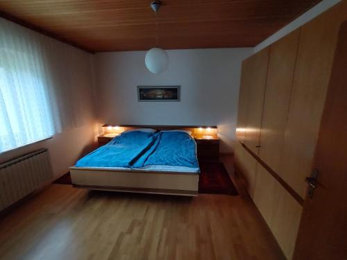 a bedroom with a bed with blue sheets and lights at Haus Kink 
