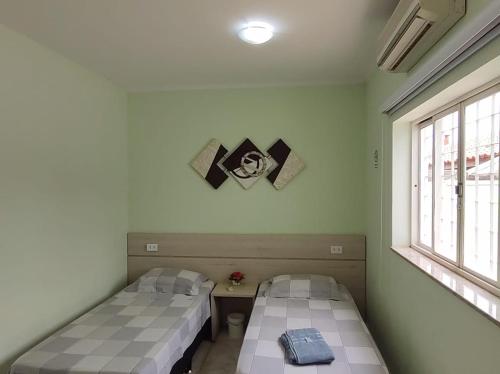 a room with two beds and a window at Pousada Happy Inn in Campinas
