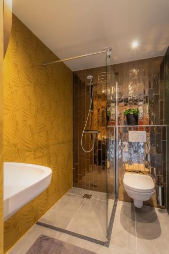 a bathroom with a shower and a toilet and a sink at Inn Hantum in Hantum