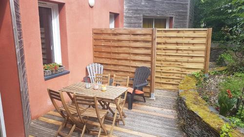 una mesa de madera y sillas en una terraza de madera en Gîte T2 A l'orée d'Angers, en Avrillé