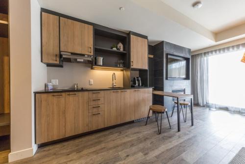 a kitchen with wooden cabinets and a table and chairs at Espace 4 Saisons in Magog-Orford