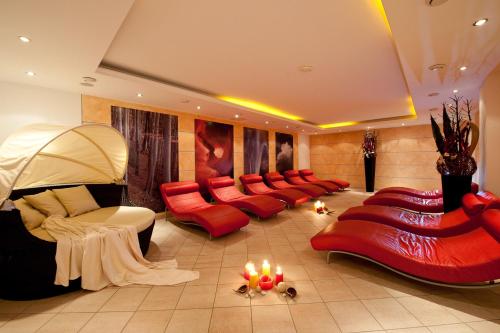 a living room with red couches and candles at Kinderhotel Laderhof in Ladis