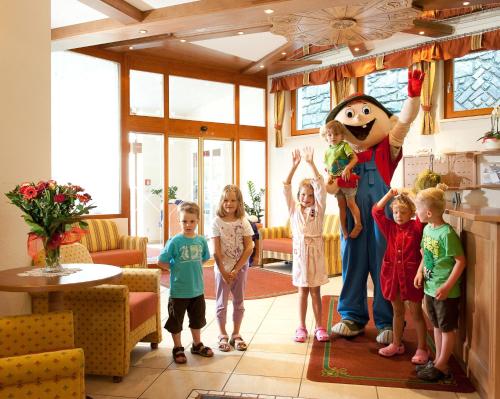 a group of children standing in a room with a mascot at Kinderhotel Laderhof in Ladis