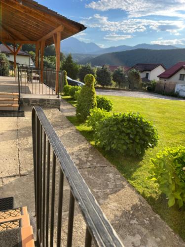 a wooden fence in front of a yard with a park at Pensiunea Funivia in Săcele