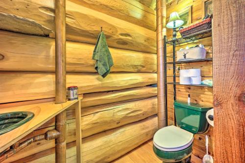 a bathroom with a wooden wall with a toilet and a sink at Rustic Hideaway Fire Pits, Grills, 87 Acres! 