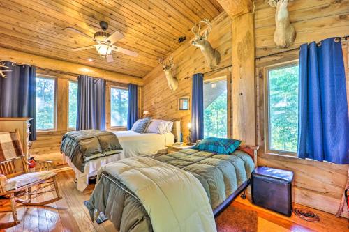 a bedroom with two beds in a log cabin at Rustic Hideaway Fire Pits, Grills, 87 Acres! 