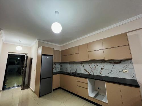 a kitchen with brown cabinets and a black counter top at Silvi C&S in Fier