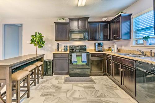 a kitchen with wooden cabinets and a counter top at 8 Mi to Downtown Little Rock Home with Fenced Yard in Little Rock