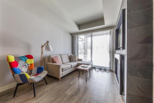 a living room with a couch and a chair at Espace 4 Saisons in Magog-Orford