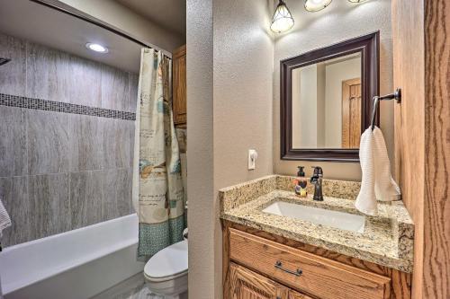 a bathroom with a sink and a toilet and a mirror at Golf Course and Lake Views Cozy Afton Condo! in Afton