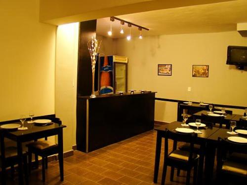 ein Restaurant mit Tischen und Stühlen in einem Zimmer in der Unterkunft Koten Hotel in Buenos Aires