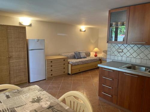 a kitchen with a refrigerator and a table and a couch at Appartamento a pochi minuti da Acciaroli sul mare in Acciaroli
