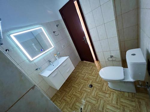 a bathroom with a toilet and a sink and a window at Silvi C&S in Fier
