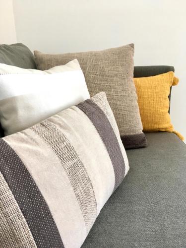- un ensemble d'oreillers sur un canapé dans l'établissement Dans une maison, appartement indépendant et jardin, à Perpignan