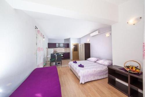 um quarto com uma cama grande e um tapete roxo em Apartman Goga em Tučepi