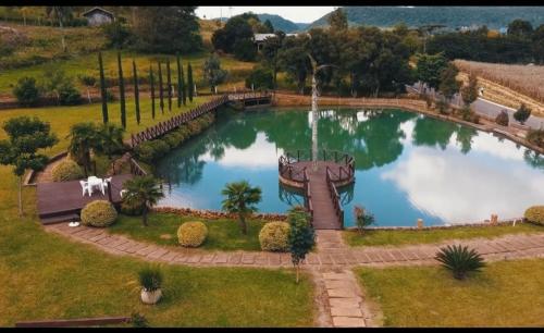 a large pond with a fountain in a park at Palast Haus Pousada in Gramado