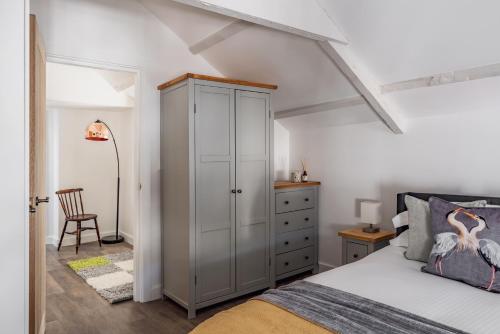 a bedroom with a white cabinet and a bed at Pickle Pot Loft- 2 bedroom apartment in Hawkshead in Hawkshead