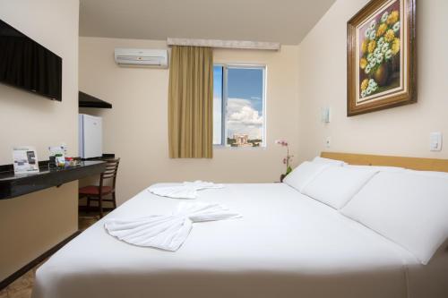 a white bed in a room with a window at Hotel Dan Inn Express Foz do Iguaçu in Foz do Iguaçu