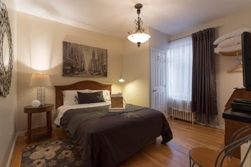 um quarto com uma cama e um lustre em Acacias Bed & Breakfast em Quebeque