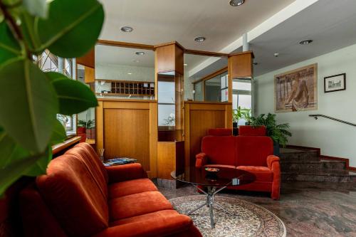 a living room with two orange chairs and a table at Hotel am Römerplatz in Ulm