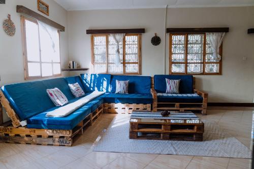 a living room with a blue couch and a table at Mkoani Homestay in Moshi
