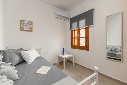 una camera con letto, specchio e tavolo di La Costa Apartment Naxos a Naxos Chora