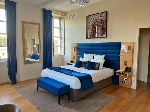 une chambre avec un grand lit et une tête de lit bleue dans l'établissement Château de Longpré, à Varilhes