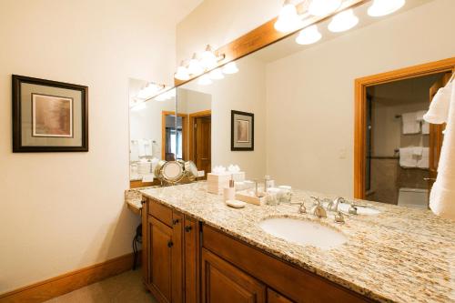 ein Badezimmer mit einem Waschbecken und einem großen Spiegel in der Unterkunft Luxury Two Bedroom Suite with Hot Tub apartment hotel in Park City