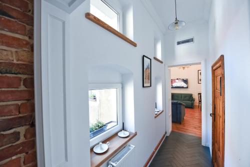 a hallway with a window and a brick wall at Wilhelmstadt Apartment 60m - PARKING in Toruń