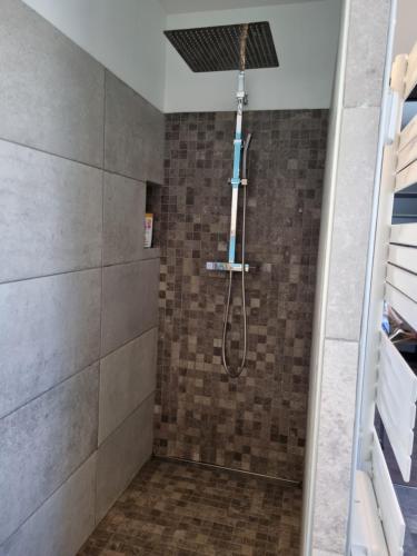 y baño con ducha con cabezal de ducha. en Maison contemporaine au cœur de la Roche-Posay, en La Roche-Posay