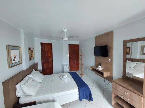 1 dormitorio con 1 cama grande y espejo en Pousada Fernandes, en Arraial do Cabo