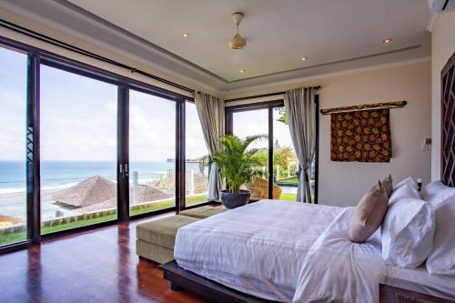 a bedroom with a bed with views of the ocean at Nusa Dua Ocean Cliff Dream in Ungasan