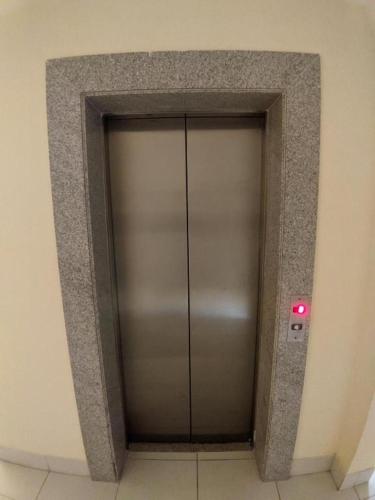 a metal elevator door in a building with a red light at Cumbuco - VGSun Apartment 402 in Cumbuco